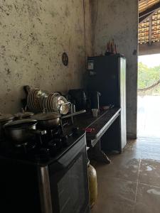 a kitchen with a stove with pots and pans on it at Varanda do Vale in Palmas +12 photos