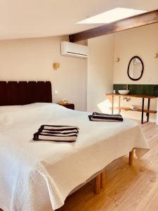 a white bed with two towels on top of it at Le Chai de Canteloup in Yvrac