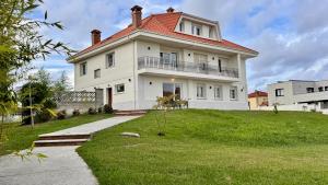 a large white house with a red roof at Quinta del Mar suites - Costa Quebrada in Soto de la Marina