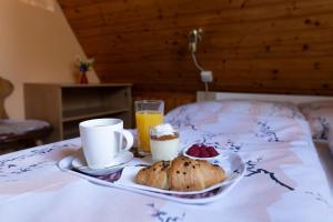 a tray of food on a bed with coffee and fruit at Horská chata LADA in Loučná pod Klínovcem