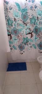 a bathroom with a shower curtain with blue flowers at Departamento luminoso y amplio in San Antonio de Areco +14 photos