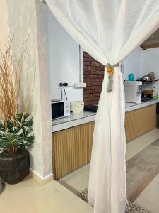 a white curtain in a kitchen with a window at Rumah Singgah in Bentong