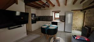 a kitchen with a small table and a tv in it at Gîte de l'Aiguillier in Castelnau-de-Montratier