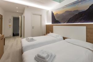 two beds in a room with a painting on the wall at Hotel Venezia in Rocca Pietore +69 photos