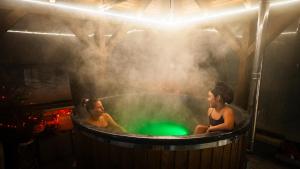 two women in a hot tub with a green ball at Nyiko Vendégház in Lupeni