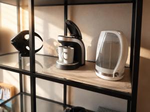 a shelf with a toaster and a coffee maker on it at Family Hotel Daugavpils in Daugavpils