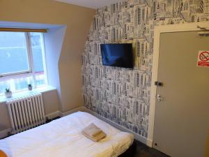 a bedroom with a wall covered in paper at Saltoun House in Fraserburgh