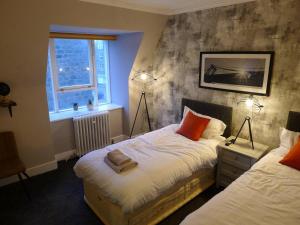 a bedroom with two beds and a window and two lamps at Saltoun House in Fraserburgh
