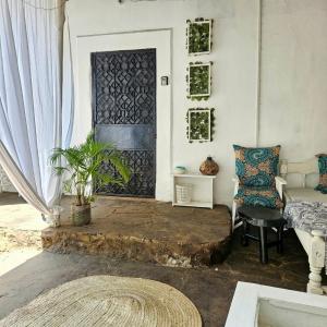 a living room with a door and a couch and a chair at Palm Paradise in Diani Beach