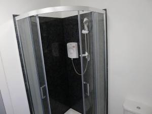 a shower with a glass door with a shower head at Saltoun House in Fraserburgh