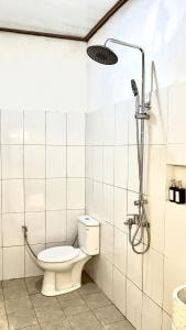 a bathroom with a toilet and a shower at Homestay Syariah Melati Borobudur in Borobudur