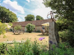 a cottage with a picnic table and a bench at Byre Cottage 2 in Pulborough