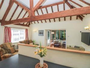a living room with a vase of flowers on a table at Byre Cottage 4 in Pulborough