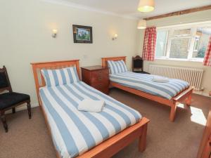 a bedroom with two beds and a chair at Byre Cottage 4 in Pulborough +41 photos