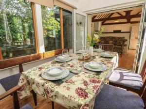 a table with plates and wine glasses on a porch at Byre Cottage 4 in Pulborough