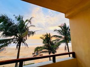a view of a beach with palm trees and the ocean at Ayomal Beach Paradise in Galle