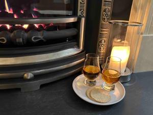 two glasses of beer on a plate next to a fireplace at The Little Beech Tree in Linlithgow