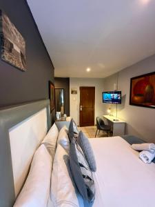 a bedroom with a large white bed with pillows at Marion Lodge in Johannesburg