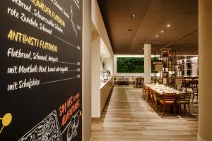 uma sala de jantar com uma mesa e uma parede de quadro negro em IntercityHotel Braunschweig em Braunschweig