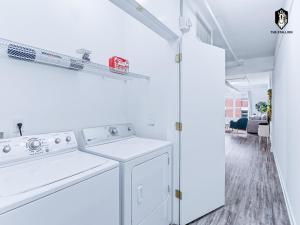 a white laundry room with a washer and dryer at The Stallion in Memphis +76 photos