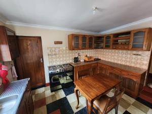 a kitchen with wooden cabinets and a wooden table at Stellas Villa in Marangu