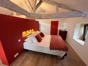 a bedroom with a large bed with a red wall at BEARS N BREAKFAST in Condom +31 photos