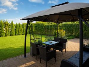 a patio with a table and chairs under an umbrella at Family Hotel Daugavpils in Daugavpils