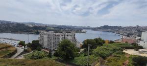 a view of a river with a building and a city at Porto & Douro Vista Apartments by Inviting in Valbom