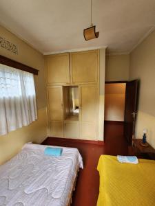 a bedroom with two beds and a cupboard at Stellas Villa in Marangu
