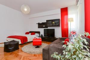 Dormitorio rojo y blanco con cama y sofá en Roman Forum Apartments, en Zadar
