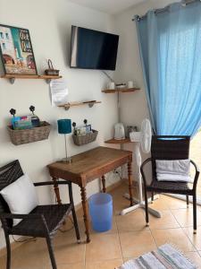 a room with a table and two chairs and a tv at Chambre d'hôtes les Galets Bleus in La Rochelle