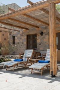 a patio with chairs and a wooden pergola at Blue Vista Patmos pool studio in Patmos
