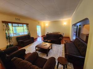 a living room with couches and a flat screen tv at Stellas Villa in Marangu
