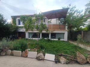 a house with an umbrella in front of a yard at Charming House with Private Pool Near Paris - Maison du Bonheur in Gournay-sur-Marne