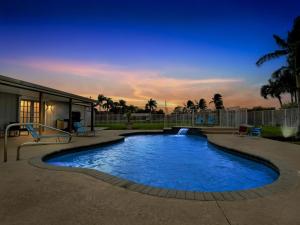 a swimming pool in a yard at night at Heated Pool - Game Room Cool in Boynton Beach
