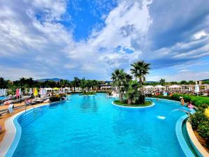 a large pool at a resort with palm trees at Харизма in Hisarya
