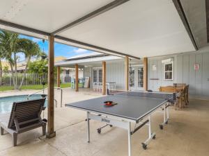a ping pong table in the middle of a patio at Heated Pool - Game Room Cool in Boynton Beach
