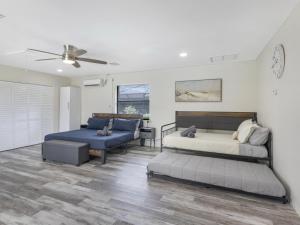 a bedroom with two beds and a couch at Heated Pool - Game Room Cool in Boynton Beach +61 photos