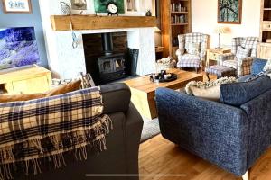 a living room with two couches and a fireplace at Dunhallin Ard in Hallin