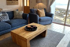 a living room with a blue couch and a coffee table at Dunhallin Ard in Hallin