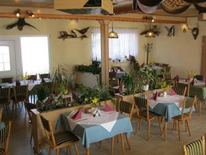 a dining room with tables and chairs and plants at Hotel Landhaus Nassau in Meißen