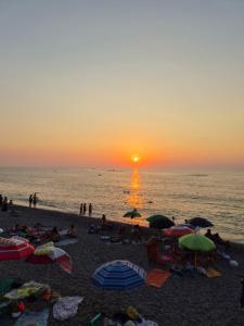 a group of people on a beach at the sunset at Roby's House in Capo dʼOrlando
