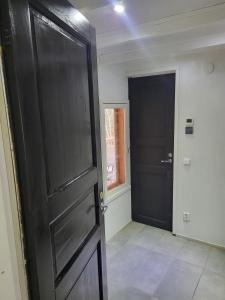 a room with a black door and a window at Axelin talo in Iitti