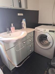 a bathroom with a sink and a washing machine at Axelin talo in Iitti