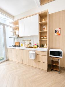 a kitchen with white cabinets and a microwave at Willow House in Padalarang