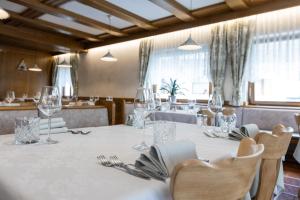 a dining room with a table with glasses and chairs at Hotel Venezia in Rocca Pietore