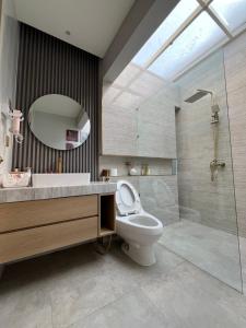 a bathroom with a toilet and a sink and a shower at Willow House in Padalarang +18 photos