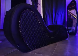 a large black chair in a room with purple lighting at L'Expérience in Villermain