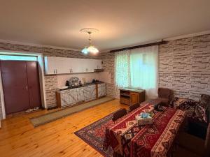 a living room with a couch and a brick wall at Panoramic apartment in Gabala