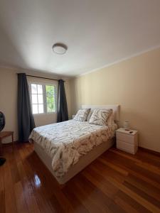 a bedroom with a bed and a window at Machico Village Apartment - Private terrace & car park in Machico
